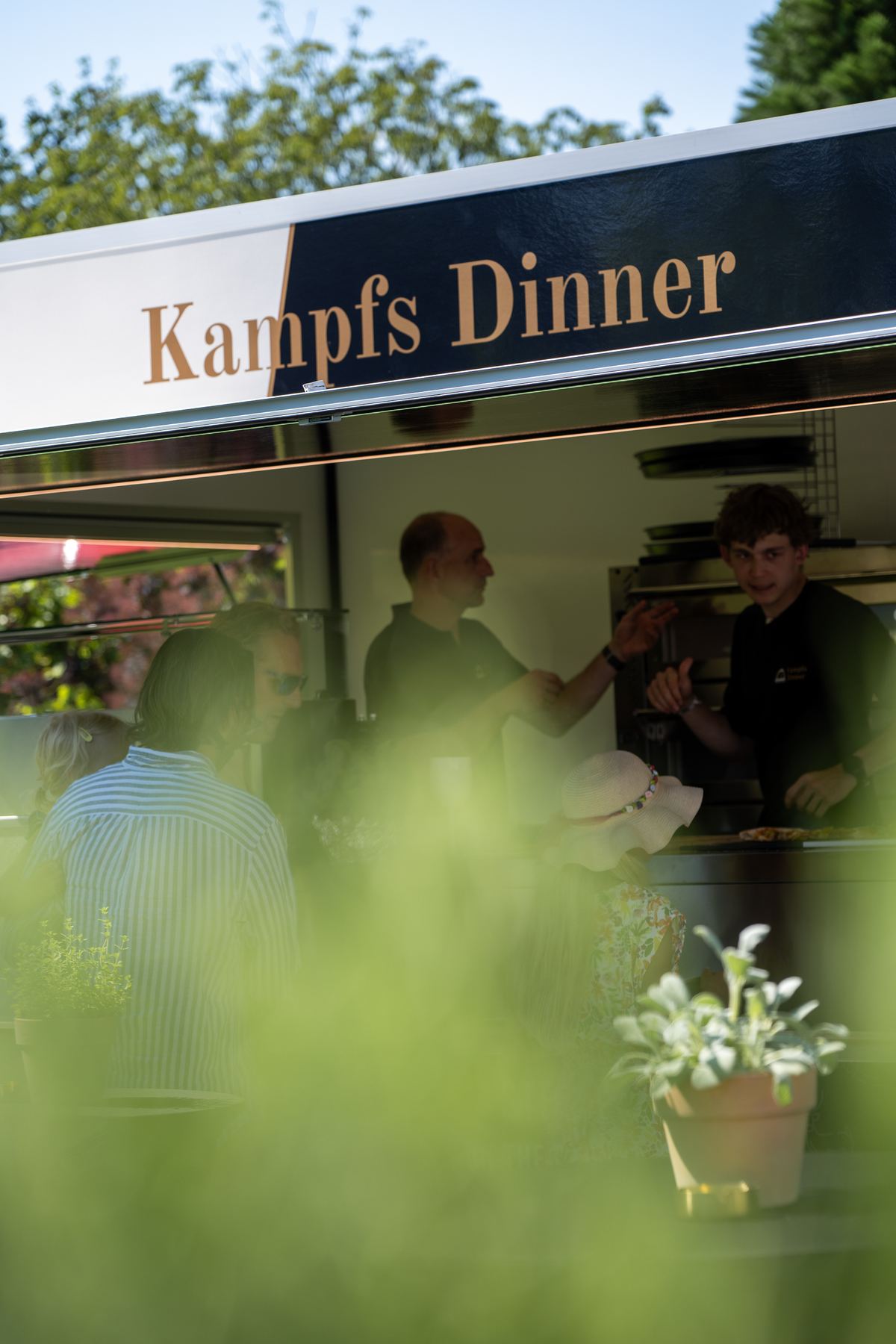 Gäste am geöffneten Schieber des Kampfs-Dinner-Anhängers