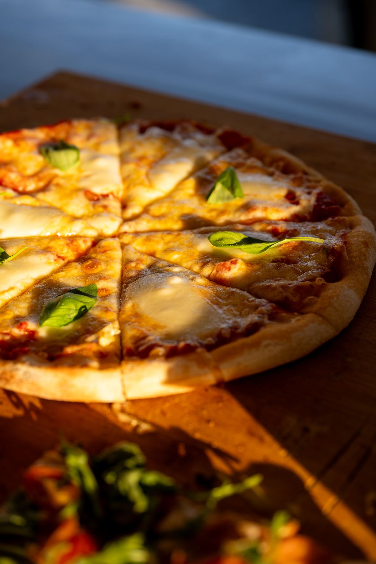Pizza Margherita mit frischem Basilikum, frisch vor Ort gebacken